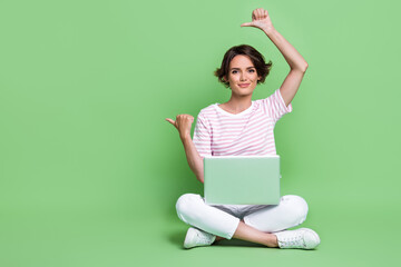 Photo of pretty lady sit floor arm demonstrate empty space cool offer proposition netbook device...
