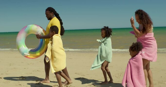 WS TS Family with children (2-3, 6-7, 8-9) walking on beach