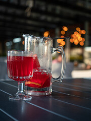 Homemade Lemonade, cold drink with red orange juice, glass and jug on the table