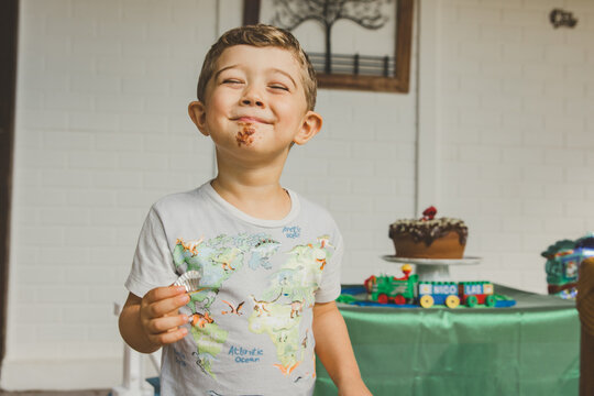 menino comendo bolo de chocolate e brigadeiro em anivers&aacute;rio