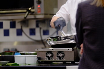 A thai chef cooking a pad thai during a masterclass. Paris, France.