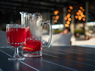 Homemade Lemonade, cold drink with red orange juice, glass and jug on the table