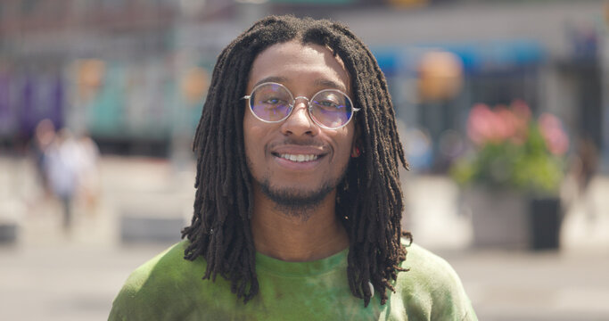Young black man on a city street smile happy face portrait with dreadlock hair