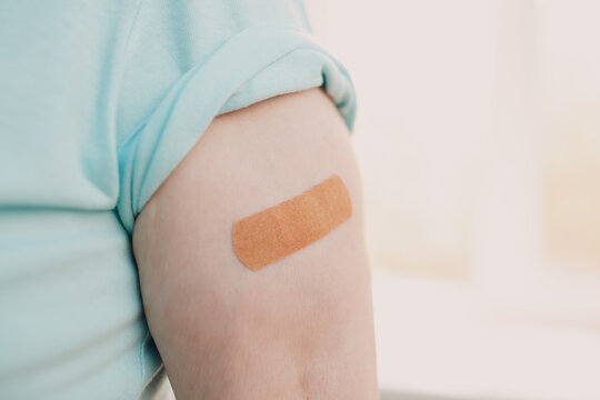 Vaccination elderly woman in doctor office with adhesive covid-19 vaccine plaster