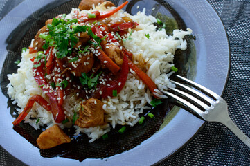 Boiled rise with chicken pieces and pepper covered with a sesame and greens.