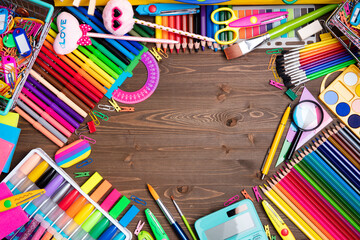 Obraz premium School supplies. Set of colorful school accessories isolated on the brown wooden background. Top view.