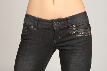 Womans waist. Hips of girl in dark jeans. Concept of diet and desire to lose weight. Woman in jeans...