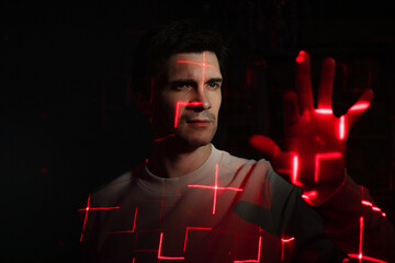 Interaction with augmented reality virtual interface, concept. A young man with projections of red...
