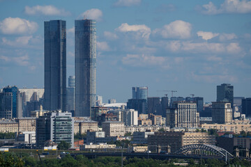 Obraz premium urban landscape with high-rise buildings, construction crane and TV tower