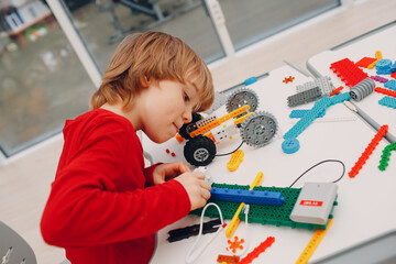Little boy kid child constructor checking technical toy. Children Robotics constructor assemble robot