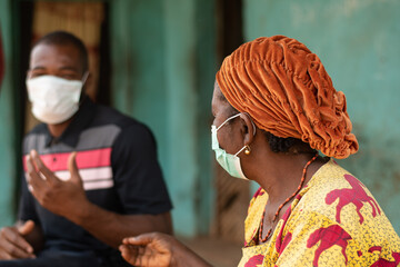 elderly african woman and young african man wearing face masks