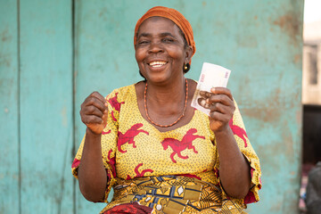 happy elderly african woman holding some money