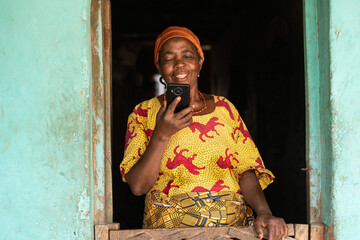 happy elderly african woman looking at her phone