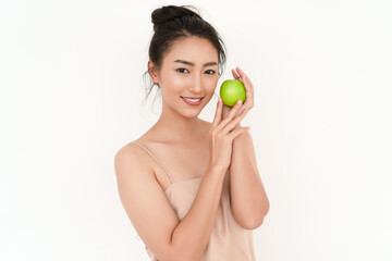 Obraz na płótnie Canvas Beautiful Asian woman holding green apple to enjoy healthy food the taste good near cheeks and looking at camera isolated on white background. Healthy food. Natural eco-friendly products concept.