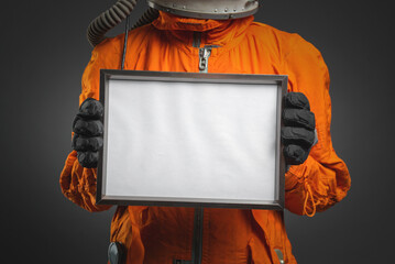 Astronaut holding in hand a blank diploma certificate with copy space. Space message. Space program...