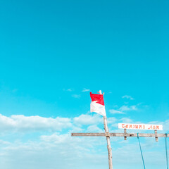 Mandalika, West Nusa Tenggara, Indonesia-August, 2019 : Indoesia red-white flag fluttered over the blue sky, selective blurred focus