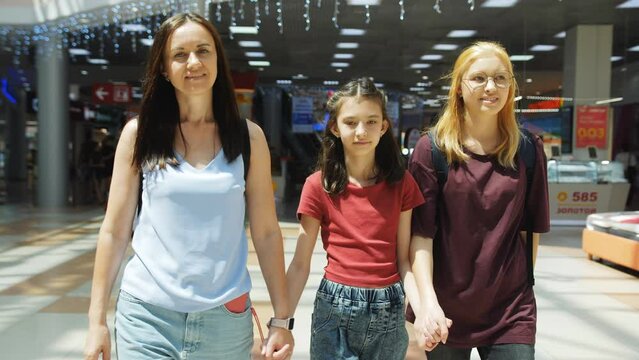 A happy family, a woman and two daughters go shopping at the mall.