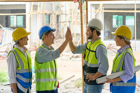 Team of foreman touch hand for join group to working with rainy day on construction site