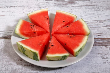 Fresh sliced watermelon composition on wooden background.