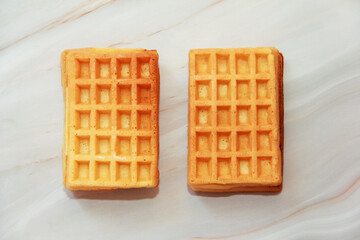belgian fluted baked sweet waffles on a gray marble background