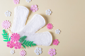 Women's sanitary napkins for the menstrual period decorated with flowers on a yellow background