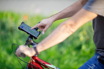 Man planning route using GPS navigation application in mobile phone on his bicycle bike