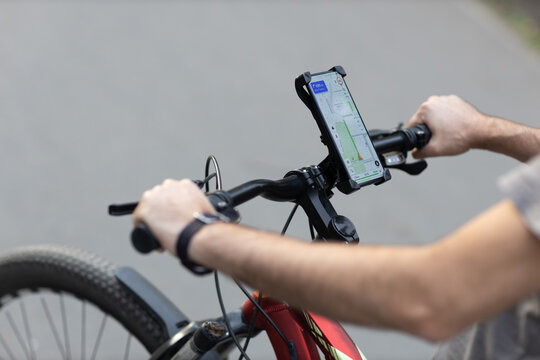 Man planning route using GPS navigation application in mobile phone on his bicycle bike