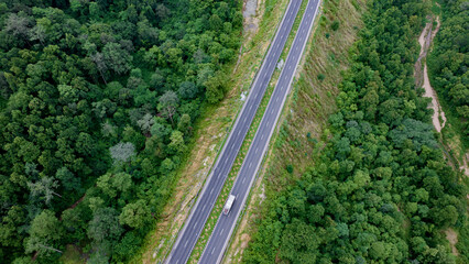 Aerial view of road going through greenery, Roads through the green forest, drone landscape