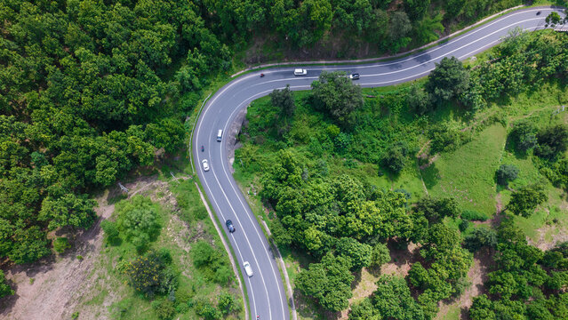Aerial view of road going through greenery, Roads through the green forest, drone landscape © Arnav Pratap Singh