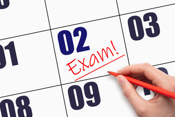 2nd day of the month. Hand writing text EXAM and drawing a line on calendar date.