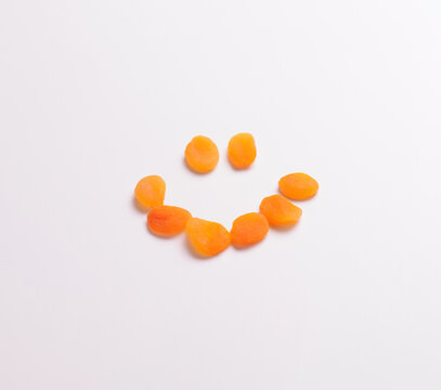 Dried apricots forming a smiley face, isolated on white, for mock ups and photo montages