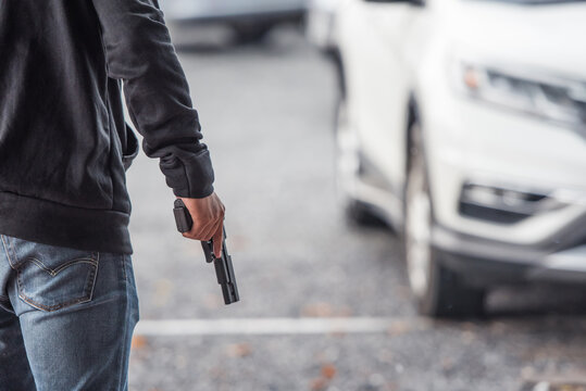 Man with a gun in car park.