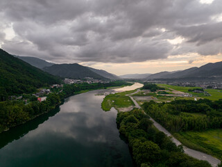River flows through rural valley and small towns after sunset