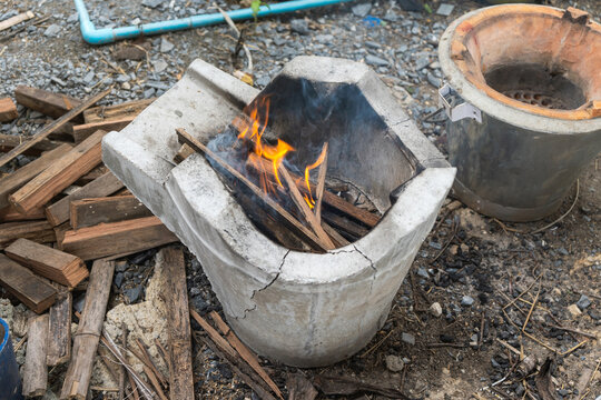 Making a fire with firewood from wood chips in charcoal stove mortar.