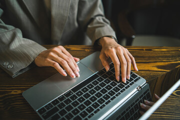 business person working with laptop computer by using hand typing a keyboard on office table desk, modern lifestyle with  internet technology online communication