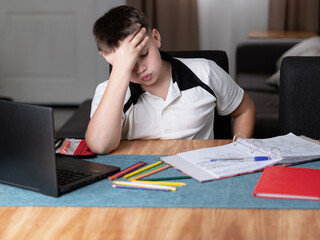 Schoolboy looking frustrated and tired while doing homework