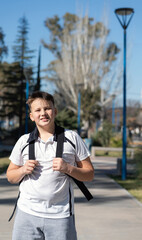 Preteen looking at the camera and smiling on his way to school