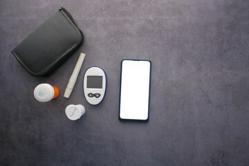  smart phone and diabetic measurement tools and pills on table 