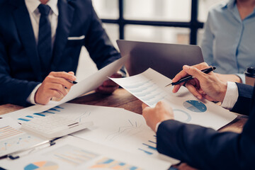 Group of business people meeting together Pointing to the graph assess business profits