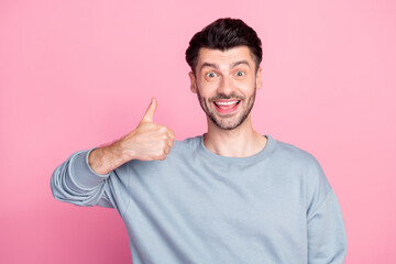 Portrait of positive cheerful man hand finger demonstrate thumb up isolated on pink color background