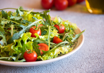 Fresh vegetable salad with tomatoes, arugola, lettuce and other ingredients, healthy eating