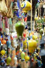 Multi-colored wall and ceiling retro  ornaments, various ceramics and threads and trinkets hung on the wall,