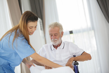 Asian nurse caring of an adult male sitting on a wheelchair. elderly healthcare concept. Young...