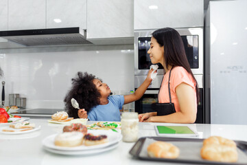 Black woman and daughter cooking and playing with flour