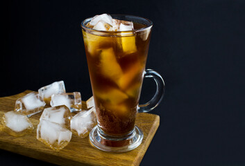 Espresso tonic in the drinking glass on the black background. Coffee drink. Close-up.Copy space.