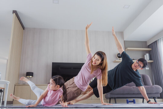 Family Asian Exercising At Home Together. Family Doing Yoga.