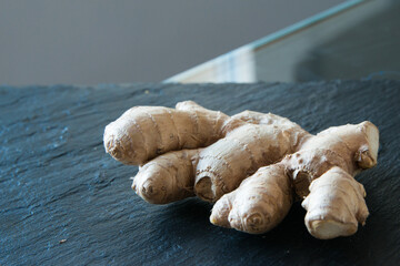 Fresh ginger root on a black kitchen counter.