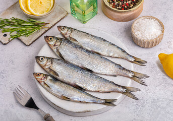Fresh sardines, lemon and salt on kitchen, close up shot. Creative fish. Fish is widely used in the cuisines of Greece, Spain and Italy, top view 
