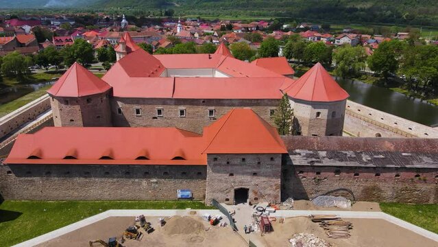 Aerial footage of the Citadel of Fagaras, in Brasov county, Romania. Video was shot from a drone with camera tilted downwards at a lower angle. Birds eye view over medieval fort.