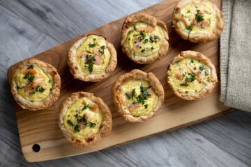 Smoked salmon tarts with caviar on cutting board